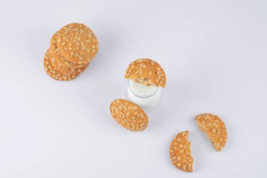 Susamlı yulaflı kurabiye ve beyaz arka planda bir bardak süt. Yüksek kalite fotoğraf