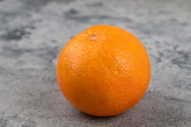 One whole fresh healthy oranges isolated on a stone background. High quality photo