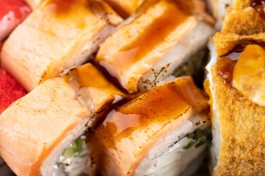 Farklı türde taze suşi ruloları ve plastik kutuda susam tohumları. Yüksek kalite fotoğraf