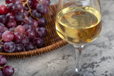 Bir kadeh beyaz şarap ve arka planda taze kırmızı üzümler. Yüksek kalite fotoğraf