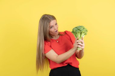 Büyük yeşil brokoli tutan güzel bir kadın modeli resmi. Yüksek kalite fotoğraf