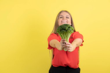 Brokoliyi kameraya gösteren güzel bir kadın modeli. Yüksek kalite fotoğraf