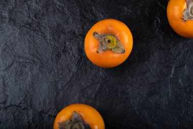 Siyah yüzeye yerleştirilmiş lezzetli olgun hurma meyveleri. Yüksek kalite fotoğraf