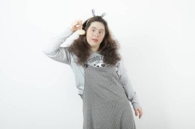 Down sendromlu sevimli bir kız beyaz çerçeveyi boş tutuyor. Yüksek kalite fotoğraf