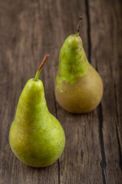 Ahşap zemin üzerinde iki olgun, lezzetli yeşil armut. Yüksek kalite fotoğraf