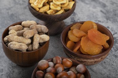 Ahşap arka planda fındıklı ve krakerli sağlıklı kurutulmuş kayısı meyveleri. Yüksek kalite fotoğraf