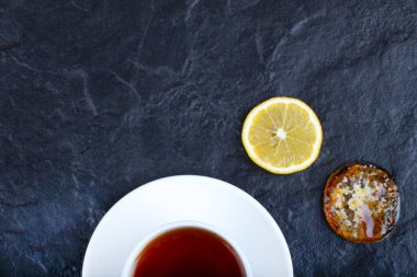 Dilimlenmiş limon ve arka planda bir fincan sıcak çay. Yüksek kalite fotoğraf