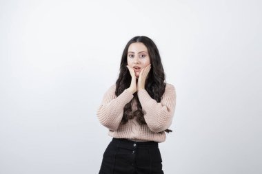 Beyaz duvara karşı duran ve poz veren güzel bir kadın resmi. Yüksek kalite fotoğraf