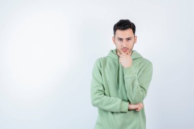 Kapüşonlu ve kameraya poz veren genç yakışıklı bir adam. Yüksek kalite fotoğraf