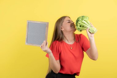 Sağlıklı brokoliyle çerçevesini tutan güzel bir kadın modeli. Yüksek kalite fotoğraf