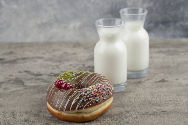 Çikolatalı çörek ve taş yüzeyde taze sütle süslenmiş. Yüksek kalite fotoğraf