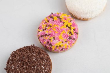 Beyaz arka plana renkli serpiştirilmiş üç taze kurabiye. Yüksek kalite fotoğraf