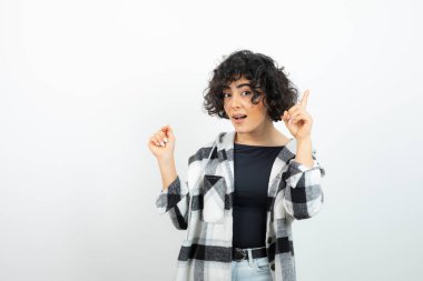 Kısa saçlı esmer bir kızın, günlük kıyafetleri içinde kameraya bakarken görüntüsü. Yüksek kalite fotoğraf