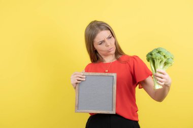 Sağlıklı brokoliyle çerçevesini tutan güzel bir kadın modeli. Yüksek kalite fotoğraf