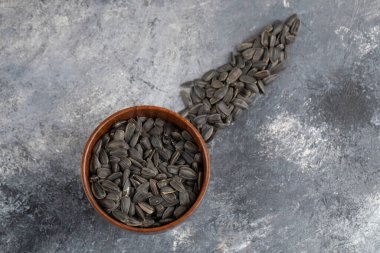 Bir kase kavrulmuş siyah ayçiçeği çekirdeği mermer arka planda. Yüksek kalite fotoğraf
