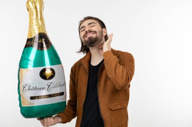 Şampanya şeklinde balon tutan sakallı yakışıklı adam. Yüksek kalite fotoğraf