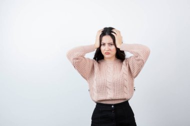 Kafasını beyaz duvara dayamış güzel bir kadın görüntüsü. Yüksek kalite fotoğraf