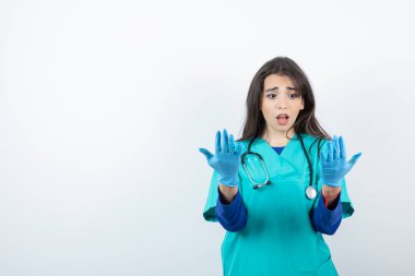 Steteskoplu genç hemşirenin portresi tıbbi eldivenlere bakıyor. Yüksek kalite fotoğraf