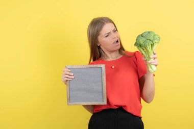 Sağlıklı brokoliyle çerçevesini tutan güzel bir kadın modeli. Yüksek kalite fotoğraf