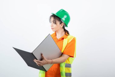 Koruyucu miğferli kadın mühendis ve sarı yelek klasörü. Yüksek kalite fotoğraf