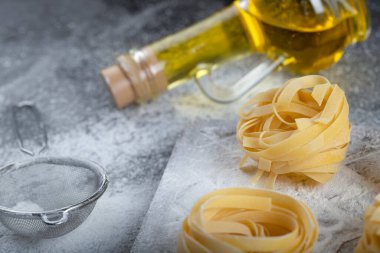 Tahta ahşap tagliatelle tahtasının üzerinde un ve zeytinyağı olan yuvaları var. Yüksek kalite fotoğraf