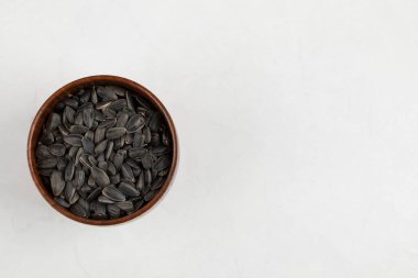 Beyaz arka planda bir kase kavrulmuş siyah ayçiçeği çekirdeği. Yüksek kalite fotoğraf