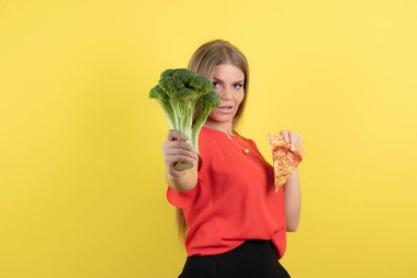 Brokoli ve lezzetli pizza tutan güzel bir kadın modeli resmi. Yüksek kalite fotoğraf