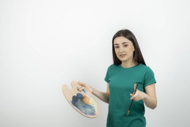 Renkli fırça ve palet kullanan genç, güzel bir sanatçı. Yüksek kalite fotoğraf