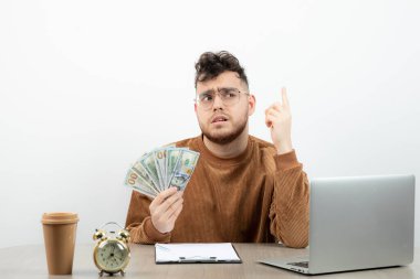 Ciddi bir muhasebeci masasında oturmuş paraları sayıyor. Yüksek kalite fotoğraf