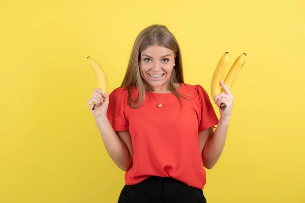 Αυτοπεποίθηση Νεαρή Γυναίκα Κρατώντας Μπανάνες Απομονωμένη Πάνω Από Κίτρινο Φόντο — Φωτογραφία Αρχείου