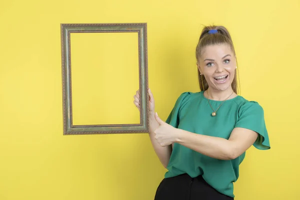 Porträt Einer Jungen Verspielten Frau Mit Leerem Fotorahmen Auf Gelbem — Stockfoto