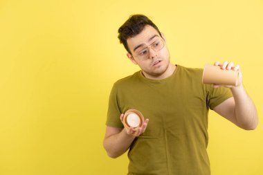 Gözlüklü genç adam boş bardak gösteriyor. Yüksek kalite fotoğraf