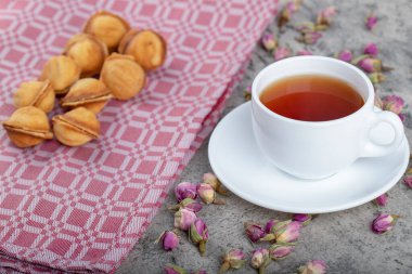 Karamelli ceviz şeklinde kurabiyeler ve arka planda bir fincan çay. Yüksek kalite fotoğraf