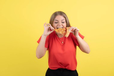 Lezzetli bir dilim pizza yiyen çekici bir kadın görüntüsü. Yüksek kalite fotoğraf