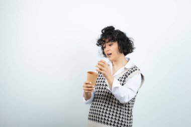 Duvarda açık kahve tutan esmer genç kızın portresi. Yüksek kalite fotoğraf