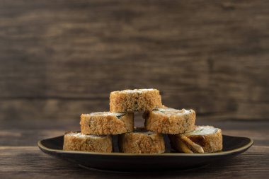 Siyah suşi ruloları ahşap bir masanın üzerine yerleştirilmiş. Yüksek kalite fotoğraf