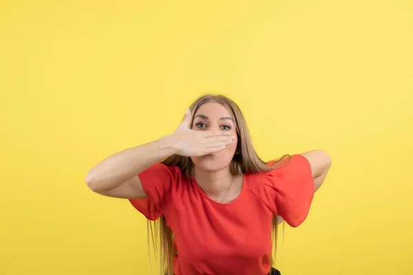 Sarı Duvarda Eli Olan Ağzı Kapalı Genç Bir Kadının Fotoğrafı — Stok fotoğraf