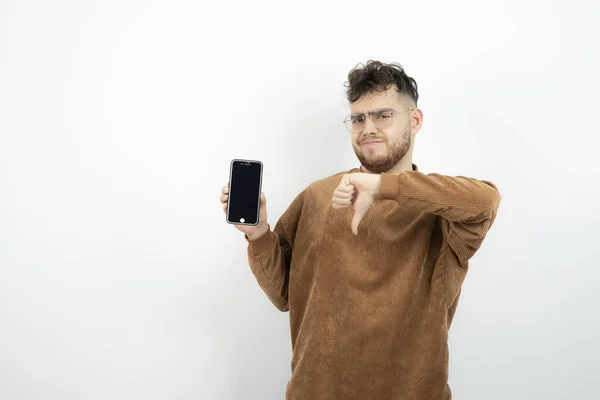 Portret Młodego Człowieka Okularach Trzymającego Komórkę Opuszczającego Kciuki Wysokiej Jakości — Zdjęcie stockowe