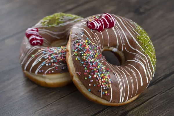 Donuts Chocolate Decorados Com Polvilhas Bagas Fundo Madeira Foto Alta — Fotografia de Stock