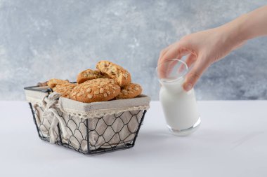 Yulaf ezmeli kurabiyelerin yanında bir sürahi süt tutan kadın. Yüksek kalite fotoğraf