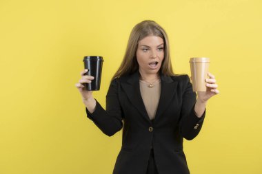 Güzel genç iş kadını kameraya kahve fincanları gösteriyor. Yüksek kalite fotoğraf