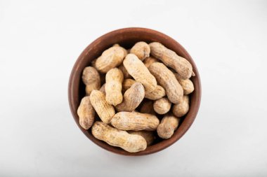 Beyaz arka planda izole edilmiş kabuklu organik fıstık kasesi. Yüksek kalite fotoğraf