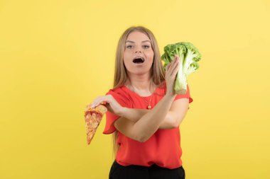 Brokoli ve lezzetli pizza tutan güzel bir kadın modeli resmi. Yüksek kalite fotoğraf