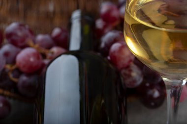 Kırmızı üzümlü hasır sepet ve arka planda beyaz şarap. Yüksek kalite fotoğraf