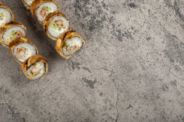 Taştan arka planda somonlu sıcak suşi ruloları. Yüksek kalite fotoğraf