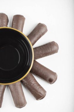 Beyaz bir arka plana yerleştirilmiş bir fincan içecekle bir çukulata çemberi. Yüksek kalite fotoğraf