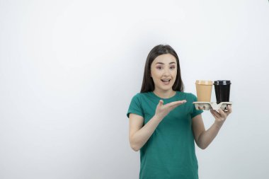 Kahve fincanı ayakta duran mavi tişörtlü güzel bir kadın resmi. Yüksek kalite fotoğraf