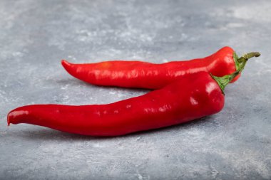 Mermer zemin üzerine iki kırmızı biber yerleştirilmiş. Yüksek kalite fotoğraf