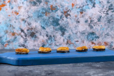 Tahta kesme tahtasına yerleştirilmiş karidesli taze lezzetli suşi ruloları. Yüksek kalite fotoğraf