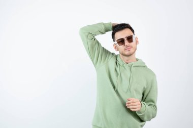 Gözlüklü yakışıklı bir adamın beyazın üzerinde poz verirken görüntüsü. Yüksek kalite fotoğraf